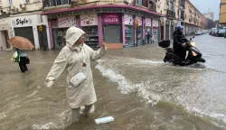 epaselect epa11718613 A woman takes a photo of a flooded street in Malaga, Andalusia, Spain, 13 November 2024. Water and hail storms in Malaga have resulted in flooding and the formation of enormous pools of water on some of the city's main streets. Malaga is on red alert for extreme risk owing to the expected heavy rainfall. EPA/MARIA ALONSO