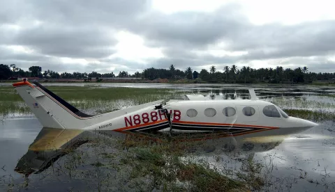 epa000483011 A US based, Cessna 340, twin engine four-seater aircraft on lease to the Bangalore based Agni Aviation floats in the marshes on Sunday 17th July 2005 after it crashed due to technical problem during landing at the Jakkur Aerodrome less than a kilometre behind the lake on Saturday evening. The two pilots survived the crash with injuries and have been admitted at a local hospital. The plane flew from Texas to Bangalore city to take part in a cloud seeding programme in the neighbouring state of Andhra Pradesh. EPA/MANJUNATH KIRAN