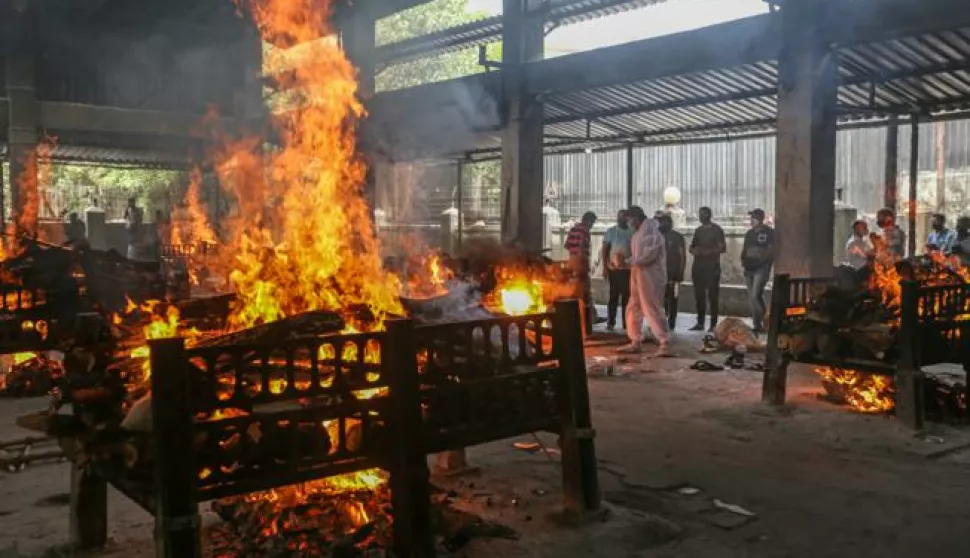 epa09154508 Relatives and municipal workers watch funeral pyres of COVID-19 victims during their funeral at a cremation ground in Virar West, on the outskirts of Mumbai, India, 23 April 2021. India recorded a massive surge of 332,730 fresh Covid-19 cases and 2,263 deaths, the highest single-day spike amid a second wave of the pandemic that is stressing health sector in the country as well as burial and cremation facilities. EPA/DIVYAKANT SOLANKI ATTENTION: This Image is part of a PHOTO SET