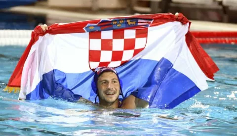 epa06116756 Loren Fatovic of Croatia celebrates with the Croatian national flag after his team won the men's water polo final match Hungary vs Croatia at the 17th FINA Swimming World Championships in Hajos Alfred National Swimming Pool in Budapest, Hungary, 29 July 2017. EPA/SZILARD KOSZTICSAK HUNGARY OUT