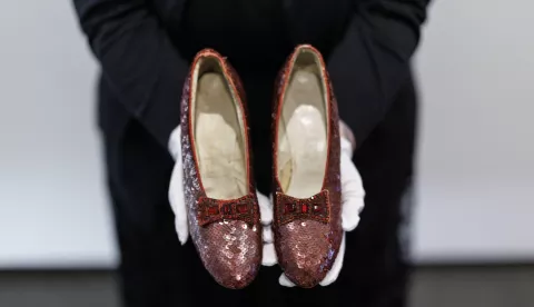 epa11745766 A gallery assistant holds movie character Dorothy's ruby slippers, worn by US actor and singer Judy Garland in the film 'The Wizard of Oz', at Heritage Auctions auction house in London, Britain, 28 November 2024. The slippers were stolen from the Judy Garland Museum in Minnesota, USA in 2005 but were recovered by FBI in 2018 and returned to their owner, Michael Shaw, who is now selling them at an auction in December 2024. EPA/TOLGA AKMEN