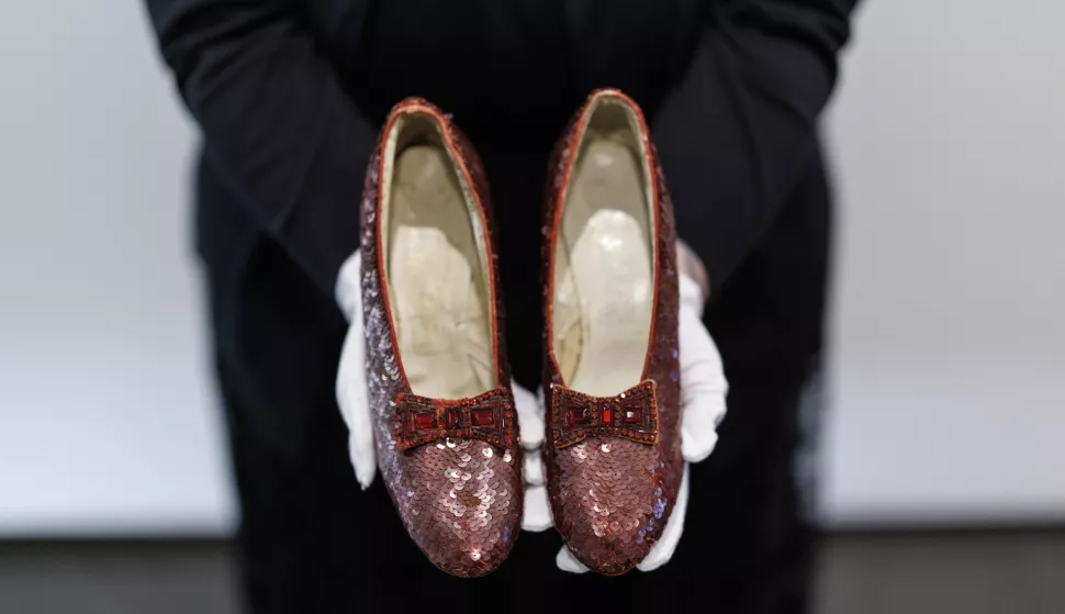 epa11745766 A gallery assistant holds movie character Dorothy's ruby slippers, worn by US actor and singer Judy Garland in the film 'The Wizard of Oz', at Heritage Auctions auction house in London, Britain, 28 November 2024. The slippers were stolen from the Judy Garland Museum in Minnesota, USA in 2005 but were recovered by FBI in 2018 and returned to their owner, Michael Shaw, who is now selling them at an auction in December 2024. EPA/TOLGA AKMEN