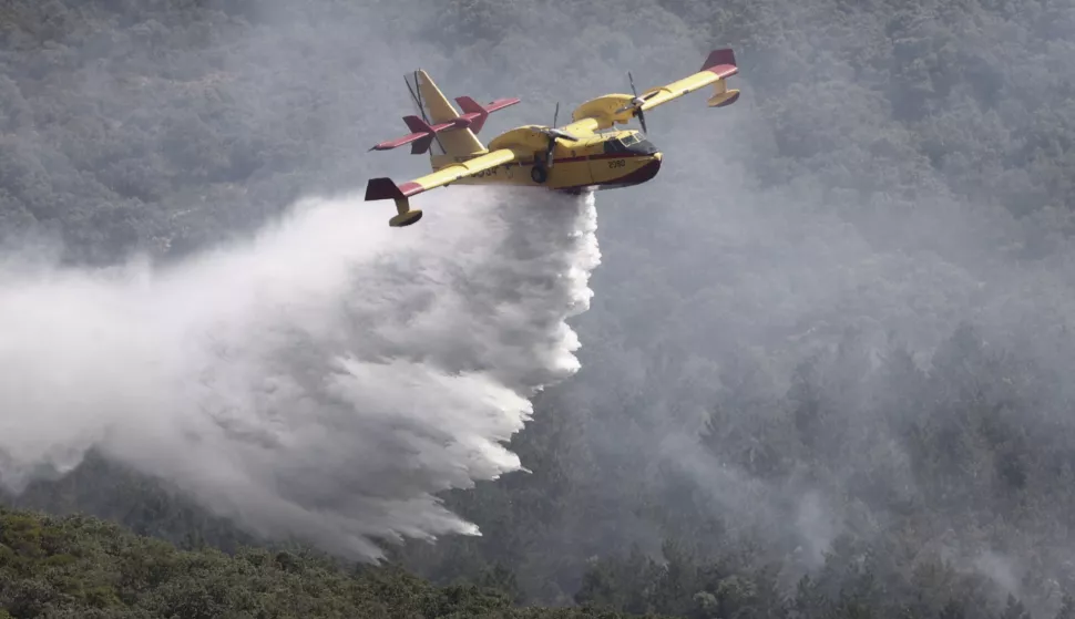 epa10014066 A Canadair firefighting aircraft drops water on a forest fire that started the previous night in Sierra de Leyre, Navarra region, Spain, 15 June 2022. A heatwave is currently sweeping through Spain, with temperatures in some areas climbing above 40 degrees Celsius. EPA/Jesus Diges