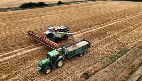 epa11546858 A picture taken with a drone shows wheat being harvested at a farm near Cambridge, Britain, 12 August 2024. According to the Energy and Climate Intelligence Unit (ECIU) think tank, climate change is impacting key crops such as potatoes and wheat, through heat, drought and floods, pushing up prices and threatening food security. In Britain, the favorable weather during the summer has helped crop conditions to recover, following an unusually wet period in the beginning of the year. EPA/NEIL HALL žetva polje