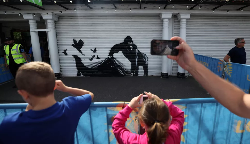 epa11547382 People view the ninth confirmed animal Banksy artwork at the London Zoo in Camden, north London, Britain, 13 August 2024. It's the ninth animal artwork the British artist has released in nine days across London. EPA/ANDY RAIN