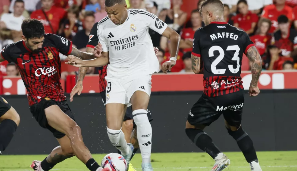 epa11554659 Real Madrid's French striker Kylian Mbappe (C) fights for the ball with Mallorca's Samu Costa (L) during the LaLiga soccer match between Real Mallorca and Real Madrid at Son Moix stadium, Palma, Balearic islands, Spain, 18 August 2024. EPA/CATI CLADERA