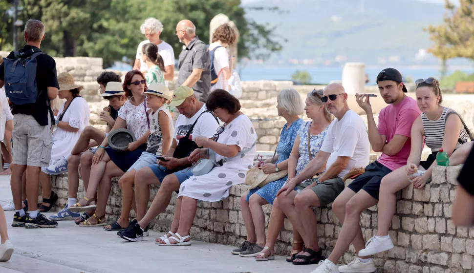 Zadar, 24.08.2024. - Turisti uživali u &scaron;etnji starom gradskom jezgrom a neki su osvježenje prona&scaron;li u moru na zadarskoj rivi.Foto HINA/Zvonko KUCELIN