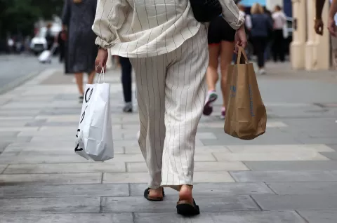 epa11566918 A shopper walks on Oxford Street in London, Britain, 27 August 2024. UK shop prices have fallen for the first time in three years, according to new figures. Shop prices fell by 0.3 percent in the first week in August compared to the same time last year, as food inflation eased and retailers offered discounts. EPA/ANDY RAIN