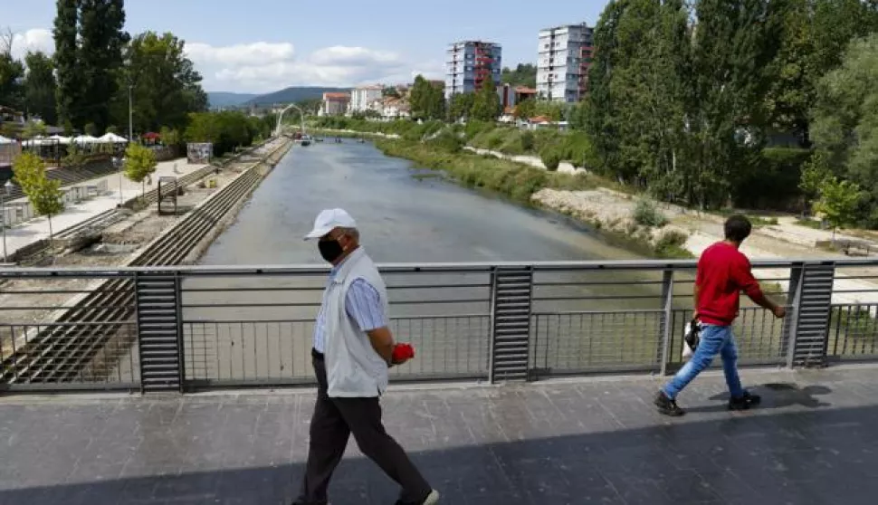 epa08643403 Pedestrians cross the main bridge of the ethnically divided town of Mitrovica, Kosovo, 03 September 2020. Kosovo's Prime Minister Abdullah Hoti and Serbia's President Aleksander Vucic will hold meetings on 03 and 04 September at the White House mediated by Richard Grenell, US president's special envoy for Belgrade-Pristina dialogue, aiming to normalize relations between the two Balkan countries. EPA/VALDRIN XHEMAJ