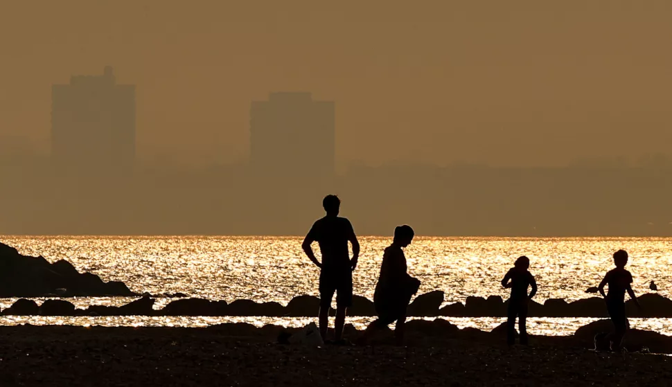 epa11585209 People enjoy a warm evening on the beach during sunset on the Baltic Sea coast near Kiel, northern Germany, 04 September 2024. EPA/FILIP SINGER