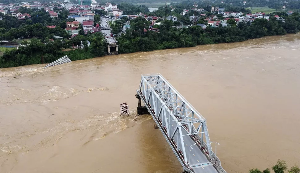 epa11594352 A handout photo made available by Vietnam News Agency shows an aerial view of the partially collapsed Phong Chau bridge into Red River, in Phu Tho province, northern Vietnam, 09 September 2024. According to state media, three people have been rescued and at least thirteen are missing following the collapse of the bridge into Red River on 09 September, after powerful Typhoon Yagi hit the country over the weekend. EPA/TA TOAN/VIETNAM NEWS AGENCY HANDOUT VIETNAM OUTHANDOUT EDITORIAL USE ONLY/NO SALES