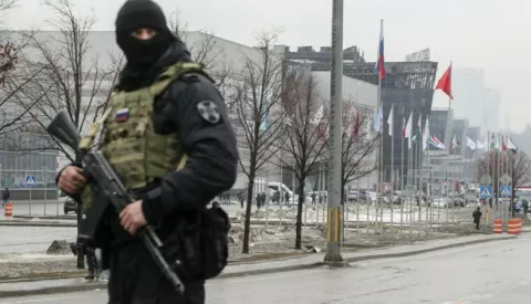 epa11238296 A Russian policeman guards near the burned Crocus City Hall concert venue following a terrorist attack in Krasnogorsk, outside Moscow, Russia, 23 March 2024. On 22 March evening, a group of up to five gunmen attacked the Crocus City Hall in the Moscow region, Russian emergency services said. 93 people were killed and more than 100 others were hospitalized, the Investigative Committee confirmed. The head of the Russian FSB, Alexander Bortnikov, reported to Russian President Vladimir Putin on 23 March on the arrest of 11 people, including all four terrorists directly involved in the terrorist attack. EPA/MAXIM SHIPENKOV