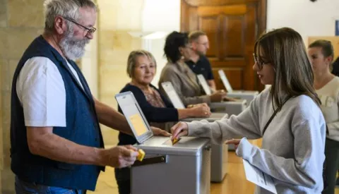 epa10932364 A woman casts her ballot during the Swiss Federal Elections in Delemont, Switzerland, 22 October 2023. On 22 October Swiss citizens will elect a new parliament. The Swiss voters elect their political representatives for the next four-year term. Parliament is made up of two chambers, the House of Representatives and the Senate. EPA/JEAN-CHRISTOPHE BOTT