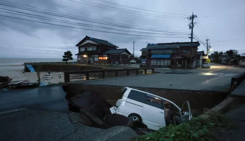 epaselect epa11617024 A car is seen in a collapsed road due to heavy rainfall in Suzu, Ishikawa Prefecture, Japan, 21 September 2024. The Japan Meteorological Agency has issued a heavy rain emergency warning for Suzu, Wajima and Noto town following torrential rain that hit New Year's Day's quake-hit Noto peninsula, causing landslides and floods. EPA/JIJI PRESS JAPAN OUT EDITORIAL USE ONLY