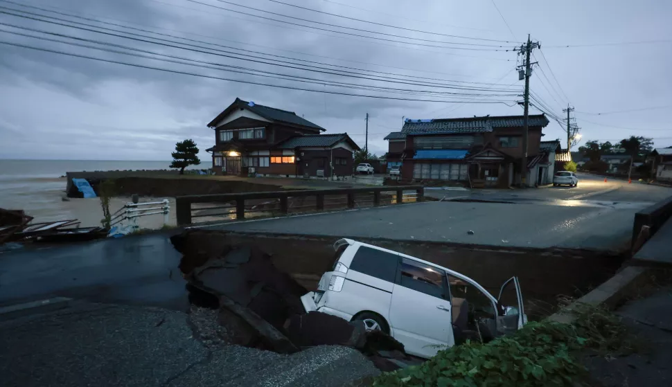 epaselect epa11617024 A car is seen in a collapsed road due to heavy rainfall in Suzu, Ishikawa Prefecture, Japan, 21 September 2024. The Japan Meteorological Agency has issued a heavy rain emergency warning for Suzu, Wajima and Noto town following torrential rain that hit New Year's Day's quake-hit Noto peninsula, causing landslides and floods. EPA/JIJI PRESS JAPAN OUT EDITORIAL USE ONLY