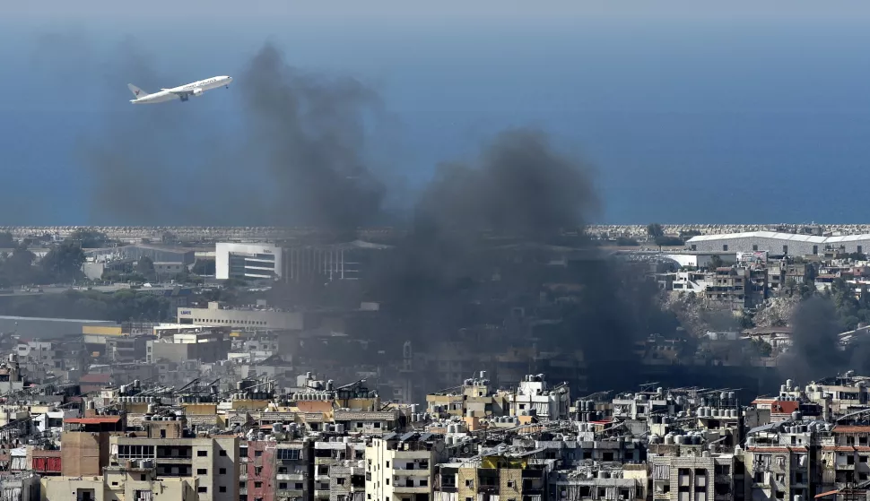 epa11643181 A plane flies amidst the smoke rising over the city following an Israeli airstrike in the Hezbollah stronghold of Dahieh, a southern suburb of Beirut, Lebanon, 05 October 2024. Lebanese Minister of Health, Firas Abiad, announced on 04 October, that nearly 2,000 people have been killed and more than 9,300 others have been injured in Lebanon since the beginning of the Hezbollah-Israeli conflict. EPA/WAEL HAMZEH