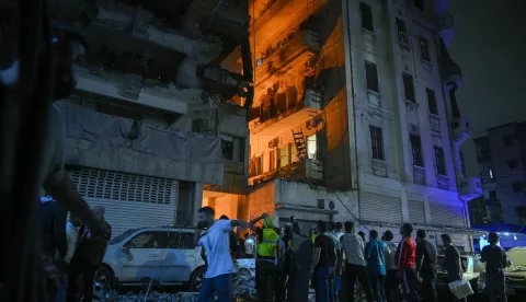 epa11653129 People gather in front of a damaged building after an Israeli military strike at the Nuwayri area in Beirut, Lebanon, 10 October 2024. According to the Lebanese Minister of Health, more than 2,100 people have been killed and more than 9,900 others have been injured in Lebanon since the beginning of the Israeli-Hezbollah conflict. Israel's military has been conducting 'extensive strikes' on Hezbollah targets in Lebanon. EPA/WAEL HAMZEH