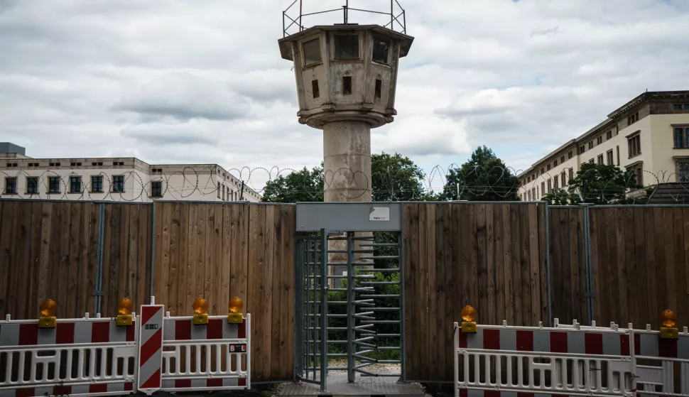 epa09410830 A former German Democratic Republic watch tower is pictured behind barbed-wire of a fence of a construction site in a side street near Potsdamer Platz square in Berlin, Germany, 31 July 2021 (issued 12 August 2021). On 13 August 2021, it's been 60 years since the beginning of the Berlin Wall's construction, which once was part of the division of East and West Germany and the so-called Iron Curtain in Europe. EPA/CLEMENS BILAN