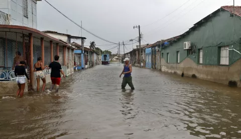 epa11651564 People walk along a street affected by flooding in Batabano, Cuba, 09 October 2024. Moderate flooding, power outages lasting over 10 hours, and residents using plastic buckets to remove water from their homes were some of the collateral effects in Cuba from Hurricane Milton's passage toward Florida, USA. EPA/Ernesto Mastrascusa