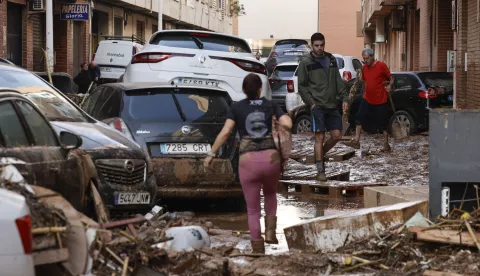 epa11694017 Residents walk through a damaged area caused by flooding and heavy rains in the municipality of Paiporta, province of Valencia, Spain, 31 October 2024. At least 95 people died in the province of Valencia and neighboring provinces following floods caused by the DANA (high-altitude isolated depression) phenomenon impacting the eastern part of the country. EPA/BIEL ALINO