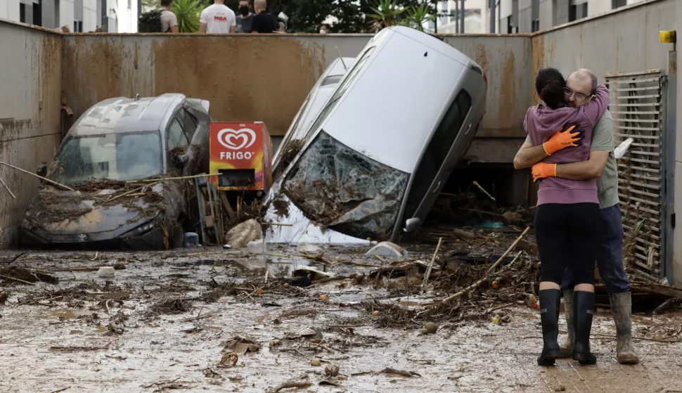 epa11696982 Two victims of the floods hug each other in front of the entrance to a parking lot blocked by cars that were swept away by flash floods in Paiporta, Valencia, eastern Spain, 02 November 2024. According to the Integrated Operational Coordination Center (CECOPI), more than 200 people have died in Valencia and neighboring provinces after floods caused by a DANA (high-altitude isolated depression) weather phenomenon hit the east of the country. According to Spain's national weather agency (AEMET), on 29 October 2024 Valencia received a year's worth of rain, causing flash floods that destroyed homes and swept away vehicles. EPA/Biel Alino