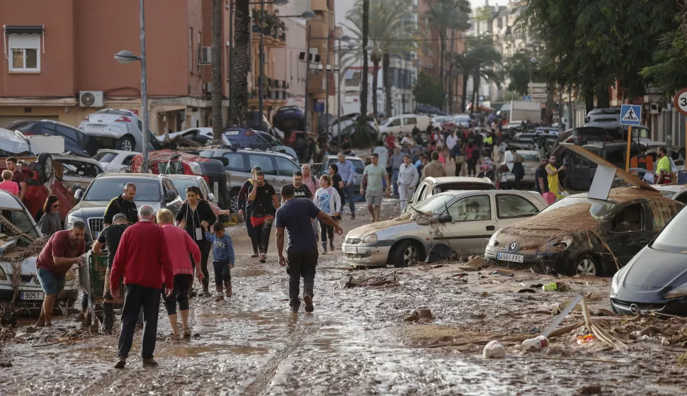 epa11692839 Residents walk along a mud-covered street in the flood-hit municipality of Paiporta, in the province of Valencia, Spain, 30 October 2024. The intense rainfall impacting the eastern part of the country resulted in at least 70 lives being lost in the province of Valencia and neighboring provinces due to the flooding. The mayor of Paiporta, located about ten kilometers southwest of Valencia, confirmed that at least 34 people died in the municipality due to the flooding. The State Meteorological Agency (AEMET) issued orange and red alerts for rainfall in multiple regions of east and southern Spain due to a DANA (isolated depression at high levels) phenomenon. EPA/MANUEL BRUQUE