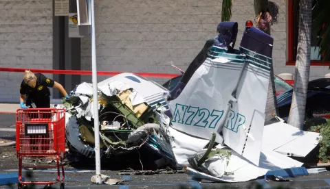 epa06929946 An investigator looks over the wreckage of a small plane that crashed into a strip mall parking lot in Santa Ana, California, USA, 05 August 2018. A twin-engine Cessna airplane crashed in the parking lot of a Staples office supply store killing all five on board, according to Orange County Fire Authority. EPA/EUGENE GARCIA