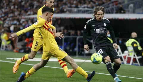 SPAIN SOCCER LALIGAepa09839301 Real Madrid's Luka Modric (R) in action against FC Barcelona players Sergio Busquets (C) and Pedri (L) during 'El Clasico', the Spanish LaLiga soccer match between Real Madrid and FC Barcelona in Madrid, Spain, 20 March 2022. EPA/Juanjo Martin