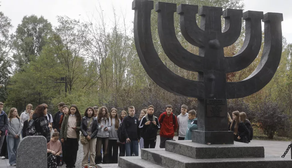 epa11654852 Young people visit the Menorah monument before a prayer in memory of the victims of the Holocaust on the eve of the Jewish religious holiday of Yom Kippur at Babyn Yar in Kyiv, Ukraine, 11 October 2024. Some 34,000 Jews were murdered in the massacres carried out by Nazi German forces during World War II in Babyn Yar ravine between 29 and 30 September 1941. In total, more than 100,000 people of different nationalities lost their lives in Babyn Yar between 1941 and 1943. EPA/SERGEY DOLZHENKO