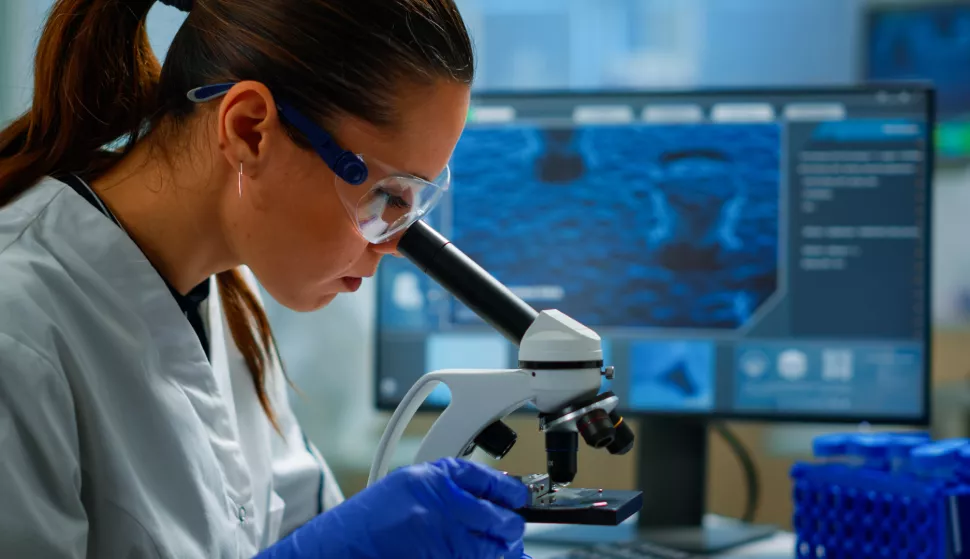 Portrait of scientist looking under microscope in medical development laboratory, analyzing petri dish sample. Medicine, biotechnology research in advanced pharma lab, examining virus evolutionlaboratorij znanost znastvenik istraživanje virus lijek mikroskop kemijafreepik