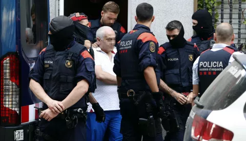 epa06840773 A defendant (C) is arrested by several Catalan regional policemen in collaboration with Europol, during a raid in a home in Badalona, Barcelona, Spain, 26 June 2018, as part of a police operation against Armenian Mafia. Spanish security forces carry out at least 70 raids in five Spanish provinces, and some 100 people are expected to be arrested in the investigation of several crimes ranging from tennis match-fixing, illegal arms trading, drug trafficking and money laundering. EPA/TONI ALBIR