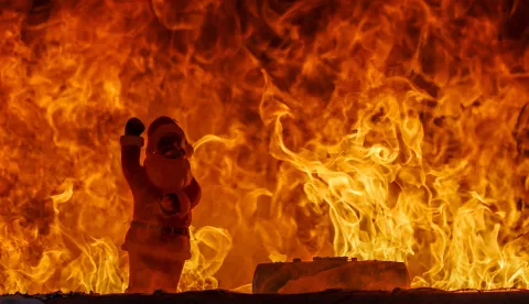 epa11745074 A Santa Claus figure burns in a mock living room during a demonstration by the Berlin Fire Department in Berlin, Germany, 28 November 2024. The Berlin Fire Department carried out an annual demonstration to raise awareness about the fire hazard of Christmas tree candles. EPA/HANNIBAL HANSCHKE