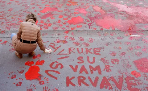 epa11751325 A protestor paints the pavement with red paint symbolizing blood during the one month anniversary of the Novi Sad train station accident in Novi Sad, Serbia, 01 December 2024. Fifteen people lost their lives in the collapse of the Novi Sad Railway Station canopy on 01 November 2024. The station building, which had been renovated and reopened on 05 July 2024, was undergoing further renovations shortly before the collapse. EPA/ANDREJ CUKIC