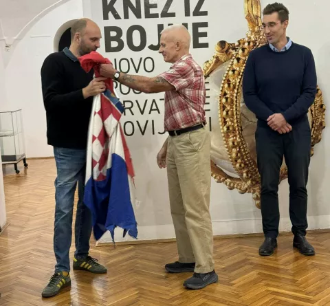 VINKOVCI - Škot Martin Cruickshank, dragovoljac Domovinskog rata koji je odmah po dolasku 1991. završio u Vinkovcima, darovao je vinkovačkom Gradskom muzeju hrvatsku trobojnicu koja se tijekom 1991. i 1992. vijorila iznad položaja koji su držali strani dragovoljci u četvrti Mala Bosna nasuprot okupiranim Mirkovcima, jednom od najtežih položaja obrane Vinkovaca.3. prosinca 2024.