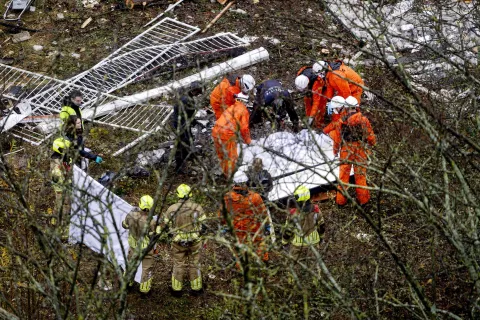 epa11762158 Rescuers work cover a body found at the site of a partially collapsed building after a fire and an explosion, in The Hague, The Netherlands, 07 December 2024. A three-storey apartment building partially collapsed on 07 December, after an explosion and a fire. EPA/RAMON VAN FLYMEN