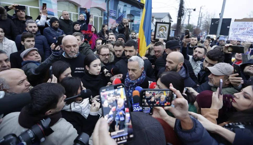 epaselect epa11764093 Calin Georgescu, Romania's independent candidate who won the first round of the presidential elections, talks to the media outside the Secondary School No. 1 polling station, where he was scheduled to cast his vote in the second round of the presidential elections in Mogosoaia, near Bucharest, Romania, 08 December 2024. The Romanian Constitutional Court (CCR) annulled the first round of presidential elections on 06 December. According to the CCR, the government will set a new election date, and the entire electoral process will be re-run, beginning with candidate registration and validation. EPA/ROBERT GHEMENT