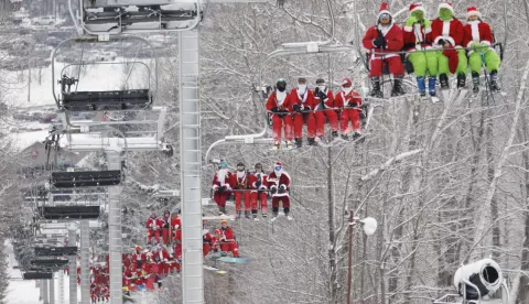 epa11765673 Skiers and snowboarders dressed as Santa Claus and the Grinch take part in the Sunday Santa ski run at the Sunday River Resort in Newry, Maine, USA, 08 December 2024. More than 300 skiers dressed in Santa-themed costumes skied down the mountain to raise money for the 'River Fund,' scholarships for students in western Maine. EPA/CJ GUNTHER