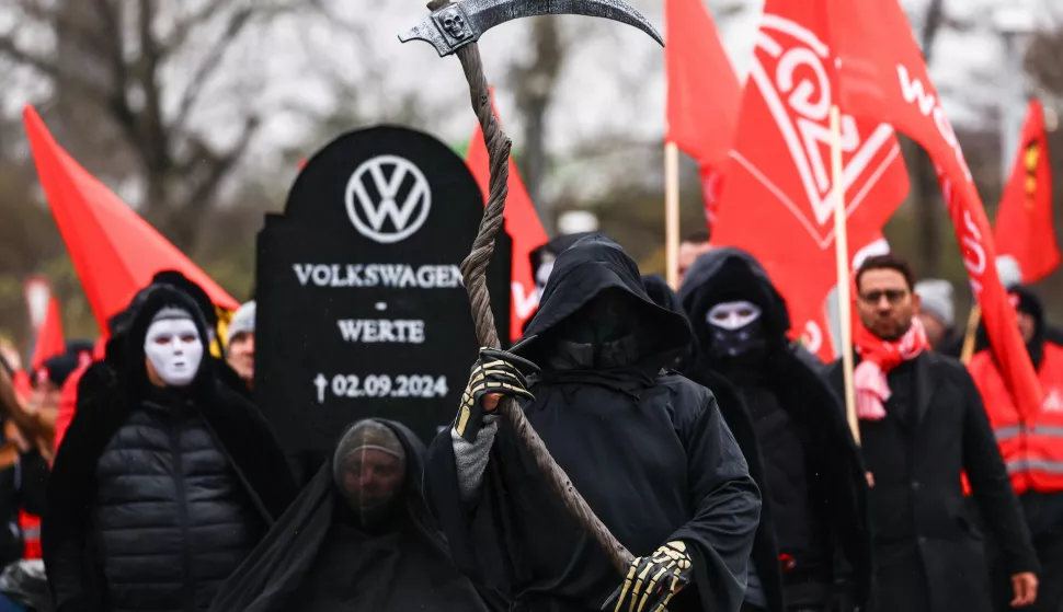 epa11732366 A protestor carries a tombstone for German automobile manufacturer Volkswagen during a protest supporting a third round of wage negotiations between IG Metall and Volkswagen AG, in Wolfsburg, Germany, 21 November 2024. Germany's largest carmaker Volkswagen may close three factories dedicated to its core brand in Germany and reduce employee wages, according to the company's workers council. This announcement sets the stage for a potentially prolonged dispute with unions representing around 120,000 German workers. EPA/FILIP SINGER