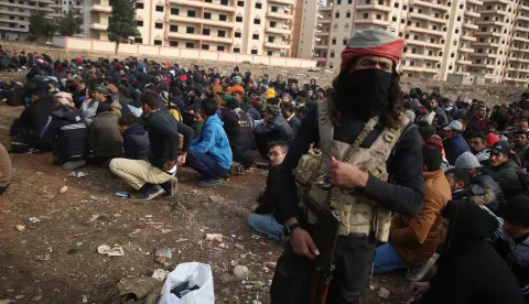 epa11765747 Detained members of the Syrian government security forces are gathered in a field by rebel soldiers in Homs, Syria, 08 December 2024. Syrian rebels entered Damascus on 08 December 2024 and announced in a televised statement the 'Liberation of the city of Damascus and the overthrow of Bashar al-Assad', as well as the release of all the prisoners. The rebels also urged the Syrian armed forces to leave Syrian public institutions, which will stay under the control of the outgoing Syrian prime minister until the official handover ceremony. EPA/BILAL ALHAMMOUD