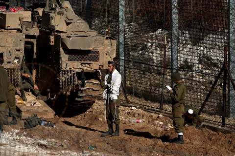 epa11766121 Israeli soldiers pray next to the border with Syria near the Druze village of Majdal Shams, in the Israeli-annexed Golan Heights, 09 December 2024. The Israeli army announced it has deployed forces to strengthen the defense of the Golan Heights and the eastern Israeli border with Syria. Syrian rebels entered Damascus on 08 December 2024 and announced in a televised statement the 'Liberation of the city of Damascus and the overthrow of Bashar al-Assad', as well as the release of all the prisoners. EPA/ATEF SAFADI