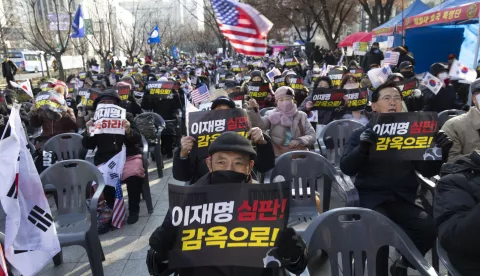 epa11767596 Supporters of President Yoon Suk Yeol hold placards reading 'put Lee Jae-myung (opposition leader) in prison' during a rally against the oppostion in Seoul, South Korea, 10 December 2024. President Yoon Suk Yeol has been prohibited from leaving the country, according to the justice ministry, amid an investigation into his declaration of martial law last week. The opposition party intends to resubmit an impeachment motion against Yoon for a vote on 14 December. EPA/JEON HEON-KYUN