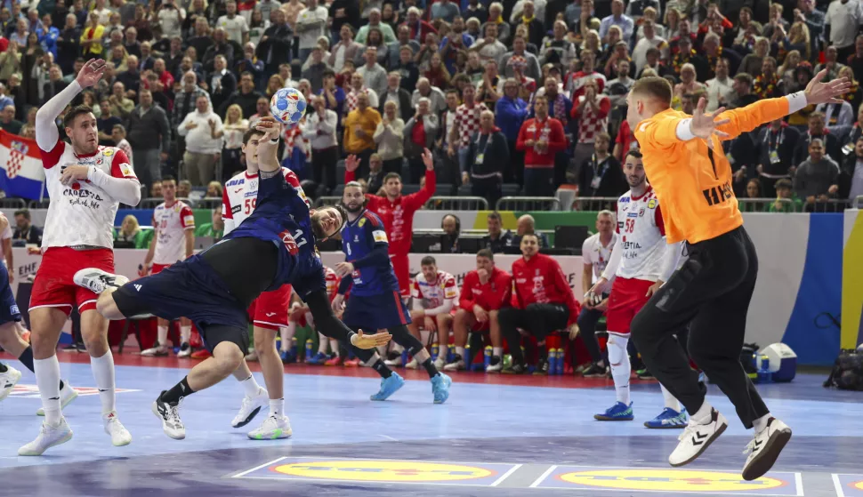 epa11088015 France's Nicolas Tournat (C) in action against Croatia's goalkeeper Dominik Kuzmanovic (R) during the EHF Men's EURO 2024 Main round group 1 handball match between France and Croatia in Cologne, Germany, 18 January 2024. EPA/CHRISTOPHER NEUNDORF