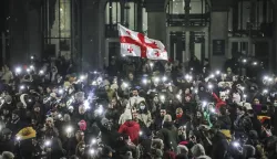 epa11760932 Supporters of the Georgian opposition hold a Georgian flag during a protest in front of the Parliament building in Tbilisi, Georgia, 06 December 2024. Thousands of pro-EU activists continue their protests in the Georgian capital against the country's ruling party decision to suspend accession talks with the European Union (EU) until the end of 2028. EPA/DAVID MDZINARISHVILI