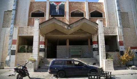 epa11777266 A portrait of ousted Syrian president Bashar al-Assad (top) hangs from the facade of prison 'Branch 215' in Damascus, Syria, 14 December 2024, after opposition forces seized the capital toppling the Syrian president. The prison, one of the Assad regime's notorious detention centers, was operated by the Syrian military intelligence service. EPA/BILAL AL HAMMOUD