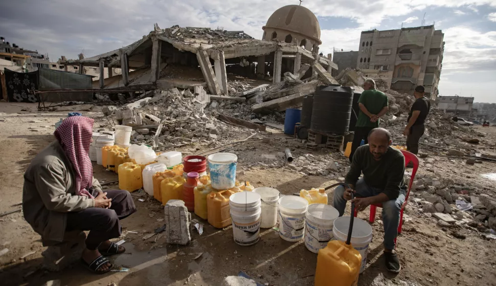 epa11727169 Palestinians wait to fill containers with drinking water amid the destruction in the Khan Younis camp, southern Gaza Strip, 18 November 2024. According to the UN, at least 1.9 million people (or nine in ten people) across the Gaza Strip are internally displaced, including people who have been repeatedly displaced. Since October 2023, only about 11 percent of the Gaza Strip has not been placed under Israeli-issued evacuation orders, the UN aid coordination office OCHA said.  EPA/HAITHAM IMAD