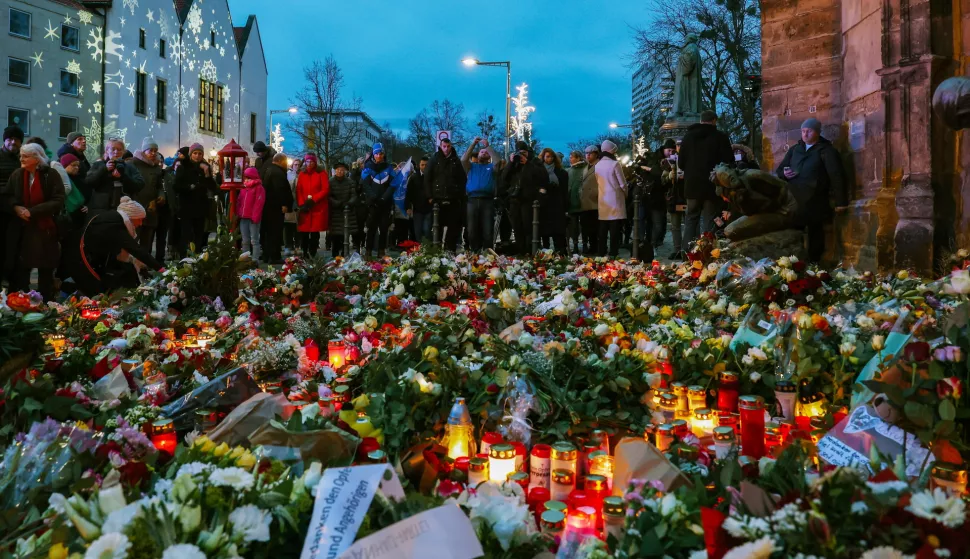 epa11788639 People gather at the official mourning site in front of St. John's Church to pay their respects following a vehicle-ramming attack on the Christmas market, in Magdeburg, Germany, 21 December 2024. According to Saxony-Anhalt State Premier Reiner Haseloff, five people were confirmed dead and at least 200 were injured, after a car was driven into a crowd at Magdeburg's Christmas market on 20 December. The suspect, a Saudi national, was taken into custody. EPA/FILIP SINGER