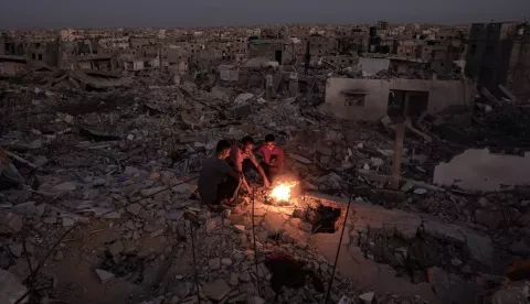 epa11671648 Palestinians sit next to a fire on the rubble of their destroyed home in Khan Yunis, southern Gaza Strip, 20 October 2024. More than 42,500 Palestinians and over 1,400 Israelis have been killed, according to the Palestinian Health Ministry and the Israel Defense Forces (IDF), since Hamas militants launched an attack against Israel from the Gaza Strip on 07 October 2023, and the Israeli operations in Gaza and the West Bank that followed it. EPA/HAITHAM IMAD