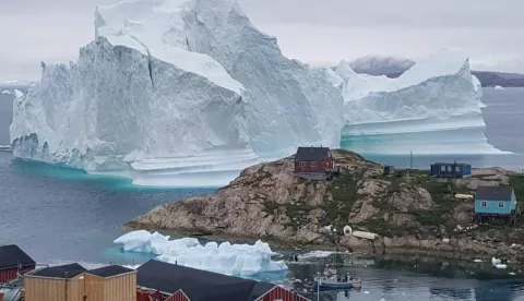 epa06885114 A general view shows an iceberg stranded near the village of Innaarsuit, in the Avannaata Municipality, northwestern Greenland, 12 July 2018 (issued 13 July 2018). The Avannaata Municipality was alarmed on 11 July, after a huge iceberg was grounded just outside the village of Innaarsuit. According to local media, police asked villagers who live closest to the water, to leave their houses over fears the iceberg could calve and affect the village with a tsunami. EPA/KARL PETERSEN DENMARK OUT