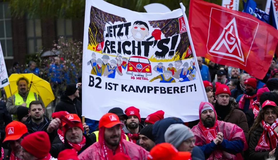 epa11766203 Volkswagen (VW) employees carry a banner that reads 'That's enough - B2 is ready for fight' as they attend a rally of the union IG Metall in front of the Volkswagen headquarters during a warning strike at the main factory of the German carmaker in Wolfsburg, Germany, 09 December 2024. Volkswagen workers stage a strike at nine Volkswagen factories in Germany as negotiations continue between the German carmaker Volkswagen and IG Metall union. Volkswagen may close three factories dedicated to its core brand in Germany and reduce employee wages, according to the company's workers council. EPA/Martin Meissner/POOL