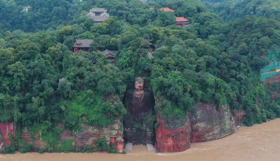 epa08612198 A view of the Leshan Giant Buddha as floodwater reaches the statue's feet following heavy rainfall in Leshan, Sichuan province, China, 18 August 2020 (issued 19 August 2020). Authorities were forced to evacuate more than 100,000 people on 18 August 2020 after flooding on the upper reaches of the Yangtze river, and flood water reaches the feet of the Leshan Giant Buddha, a 1,200-year-old world heritage site. EPA/LI XINFENG CHINA OUT